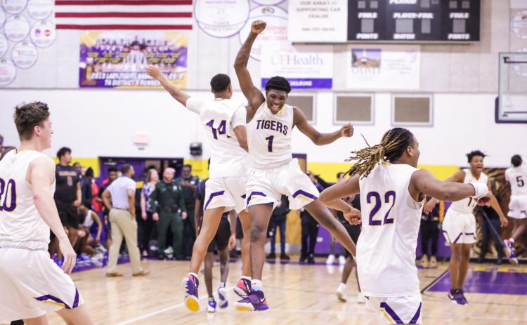 Columbia forward Marcus Peterson (1) celebrates with guard Amare Ferrell (14) after the Tigers beat Daytona Beach Mainland in last Friday’s Region 1-6A final. (BRENT KUYKENDALL/Lake City Reporter)