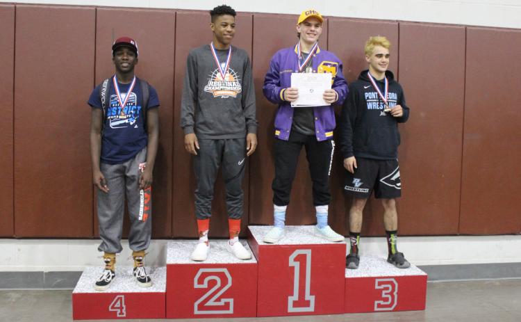 Columbia wrestler Alex McGuigan on the medal stand after winning the Region 1-2A title in the 138-pound weight class on Saturday. (COURTESY)