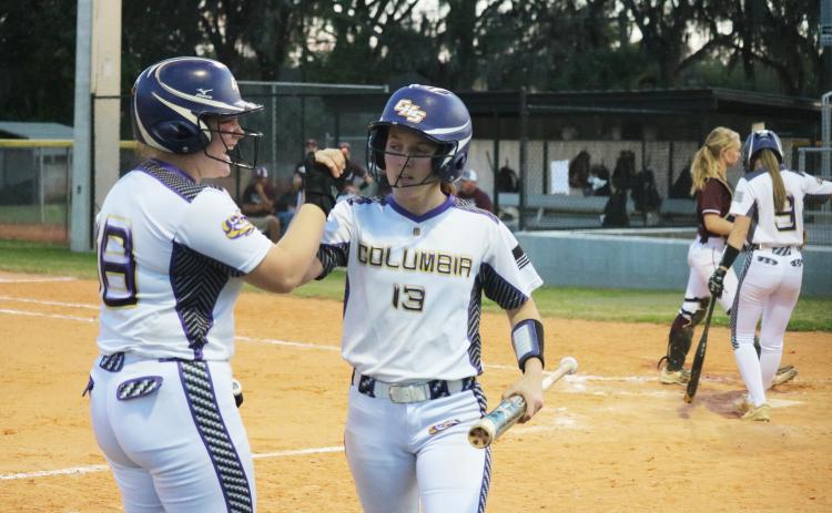 Columbia catcher Reece Chasteen celebrates with third baseman Morgan Hoyle after Hoyle scores in the first inning against Madison County on Thursday night. (JORDAN KROEGER/Lake City Reporter)