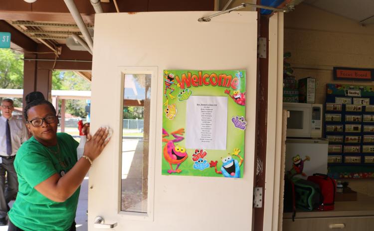 Scharlotte Stewart, Eastside Elementary School head custodian, disinfects a kindergarten classroom door on Thursday morning. The school district will have some of its employees clean and disinfect classrooms for two days next week while students and teachers are on spring break. (TONY BRITT/Lake City Reporter)