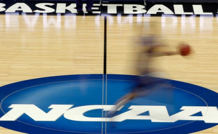 A player runs across the NCAA logo during practice at the NCAA tournament on In this March 14, 2012, in Pittsburgh. (AP FILE PHOTO)