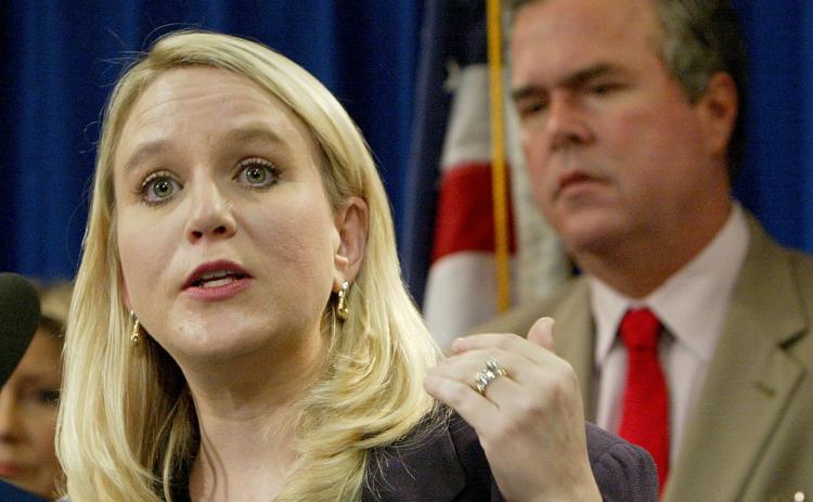 AP PHOTO In this 2004 photo, Tiffany Carr, executive director of Florida Coalition Against Domestic Violence, is seen with Gov. Jeb Bush, background right. (AP FILE PHOTO)
