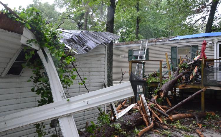 A local mobile home took a beating early Wednesday morning, after a storm rolled through the area and knocked a tree or two onto the structure. The residents took shelter in a bathroom, emerging shaken but safe. (CARL MCKINNEY/Lake City Reporter)
