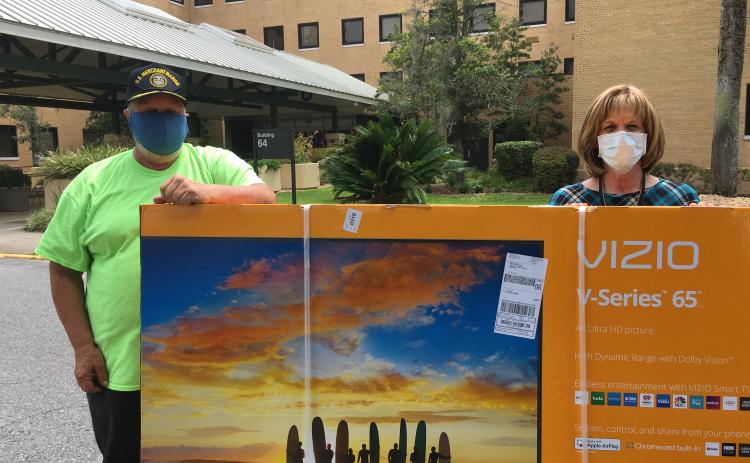 Michael Lydick, Lake City Elks Lodge #893 Veterans Committee chairman, stands with Cynthia Voltz of the Lake City VA Medical Center, as the two showoff a 65-inch television that was recently donated to the facility. The TV was one of several items donated for veterans who have been restricted from normal social outings due to the global pandemic. (COURTESY)