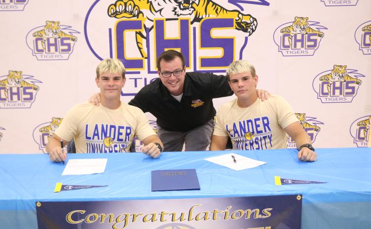 Columbia wrestlers Ian McGuigan (left) and Alex McGuigan (right) are pictured with head coach Pete Whittington (middle) after they signed their letters of intent with Lander on Thursday. (JORDAN KROEGER/Lake City Reporter)