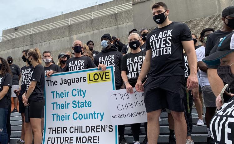 Members of the Jaguars organization, including rookie tight end Tyler Davis (right) stand on the steps of the Jacksonville Sheriff's Office during a peaceful protest on Friday. (TRIBUNE NEWS SERVICE)