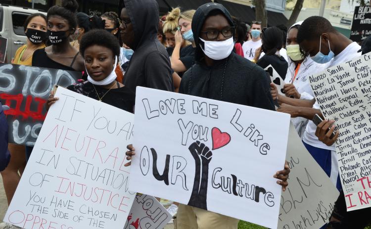 Demonstrators wave signs at traffic on U.S. 90 during a Black Lives Matter rally Friday afternoon. More than 150 people participated in a march along major roads in Lake City. (CARL MCKINNEY/Lake City Reporter)