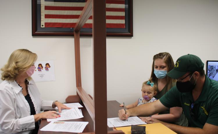 Lori Koon (clockwise from left), deputy clerk, helps Anna Marlowe, Vera Platt and Donald Platt as they complete an application for a marriage license while at the Columbia County Clerk of Courts Record Division Office on Wednesday. Due to budget cuts, the clerks office is now closed on Fridays. (TONY BRITT/Lake City Reporter)