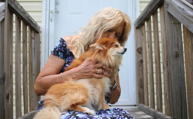 Brenda Brickel, a local registered nurse, holds Teddy Weddy Bear, her eight-pound Pomeranian that woke her Tuesday night when she feel asleep while cooking chicken wings. Brickel credits the dog with saving her life. (TONY BRITT/Lake City Reporter)
