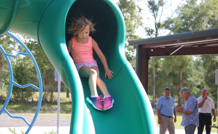 Sailor Hunter, 4, has a ‘hair-raising’ experience as she takes a ride down the sliding board Friday morning at the Columbia City Park. The park, which is fully compliant with the American Disabilities Act, is the county’s first fully inclusive playground. (TONY BRITT/Lake City Reporter)
