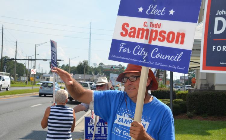 Todd Sampson, waving to traffic along Duval Street on Tuesday afternoon, is headed to a runoff election for the City Council District 13 seat. (CARL MCKINNEY/Lake City Reporter)