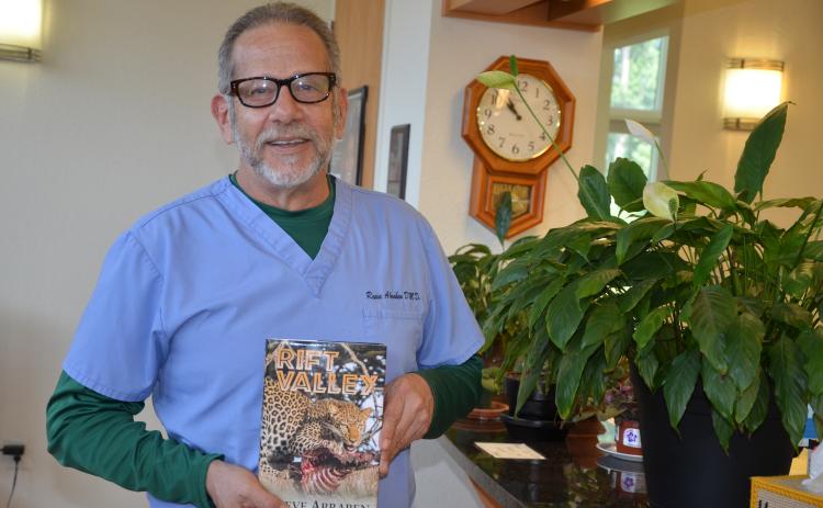 Reeve Abraben, a Lake City dentist, holds a copy of ‘Rift Valley,’ the novel he wrote and published. In addition to dentistry and writing, Abraben also is a gunsmith and is building a boat. (CARL MCKINNEY/Lake City Reporter)