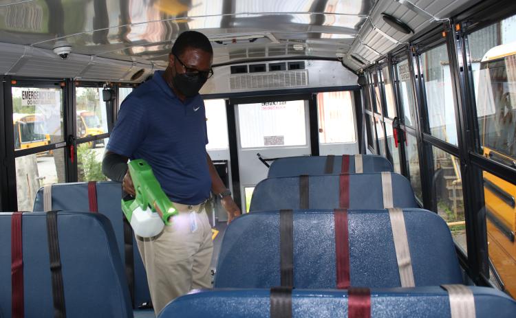 William Highland, Columbia School District Transportation Department driver and safety trainer, uses a cordless electrostatic sprayer to disinfect a school bus on Thursday afternoon while preparing for the upcoming school year which begins on Monday. (TONY BRITT/Lake City Reporter)