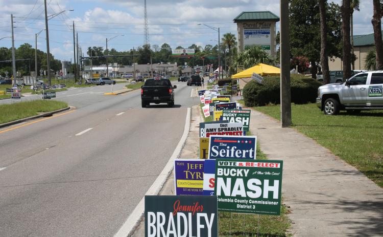 Only a few campaign workers braved 95-degree heat outside the Supervisor of Elections office Monday afternoon. (TONY BRITT/Lake City Reporter)