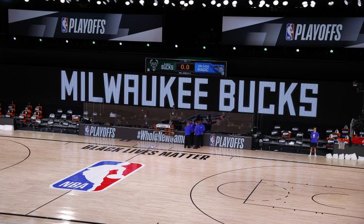 Referees huddle on an empty court at game time of a scheduled game between the Milwaukee Bucks and the Orlando Magic for Game 5 of the Eastern Conference first round series atAdventHealth Arena at ESPN Wide World Of Sports Complex on Wednesday, in Lake Buena Vista. The Bucks boycotted the game to protest the police shooting of Jacob Black. (KEVIN C. COX/Getty Images/TNS)