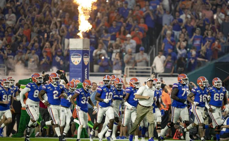 Florida Gators head coach Dan Mullen leads his team out onto the field prior to a game last season. (ALLEN EYESTONE/The Palm Beach Post)