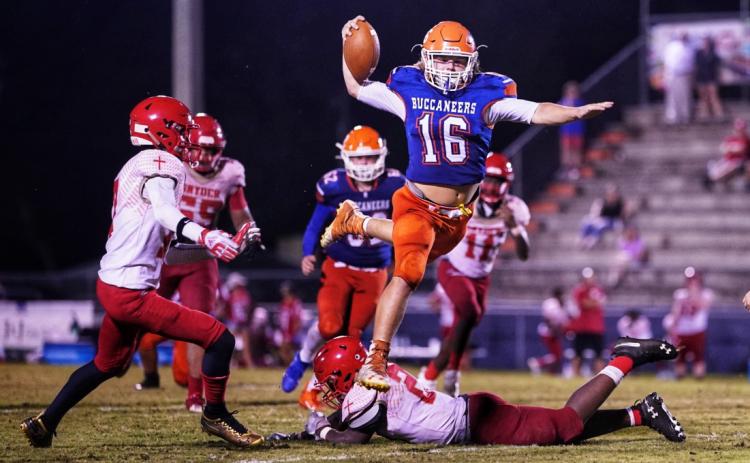 Branford’s Caden Coker leaps over a Bishop Snyder defender Friday night at Cleve Sikes Field at Buccaneer Stadium. (BRIAN LEWIS/Special to the Reporter)