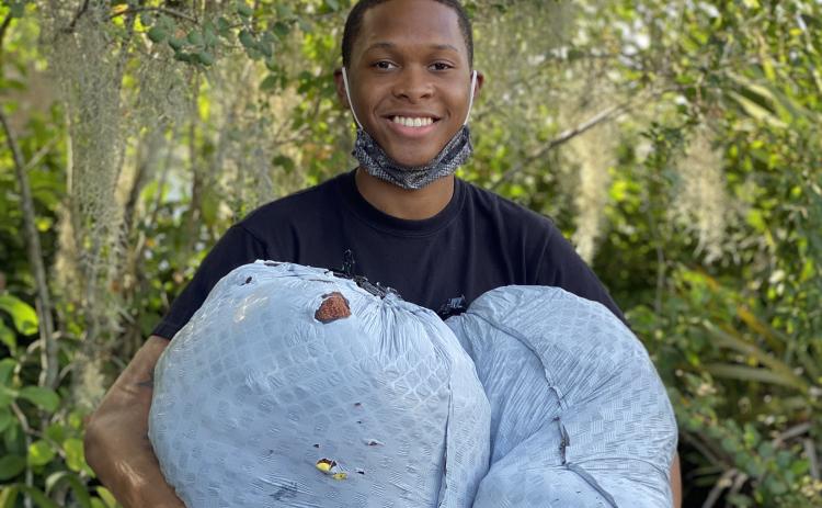 D’Andre Jefferson, holding bags of donated clothes, is hosting a clothing drive after being upset when he saw children mocked for the clothes they were wearing. (JAMIE WACHTER/Lake City Reporter)