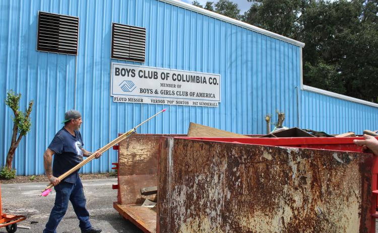 Scott Boisvert throws debris into a dumpster Thursday afternoon while cleaning out the old Boys Club of Columbia County facility. (TONY BRITT/Lake City Reporter)