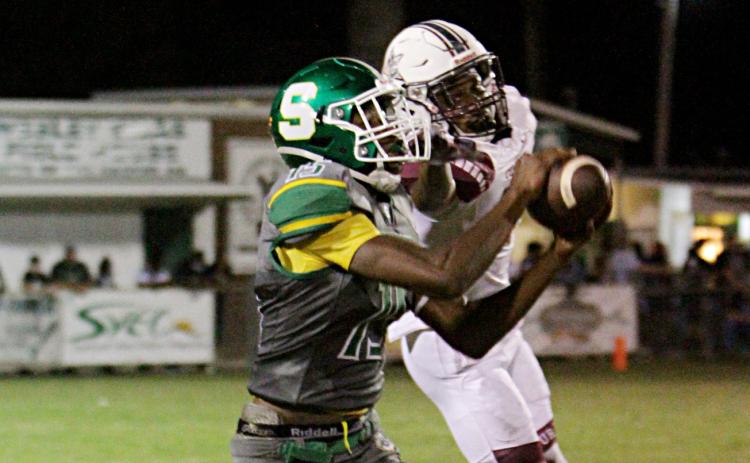 Suwannee receiver Brian Fuery catches a pass in front of a Madison County defender last Friday. (PAUL BUCHANAN/Special to the Reporter)