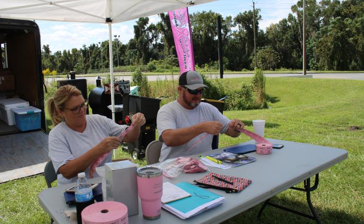 Sherry Wheeler Sheppard (left) and Donnie Feagle (right), Suwannee River Breast Cancer Awareness Association president, sell raffle tickets for the upcoming Suwannee River Breast Cancer Awareness Open Bass Tournament. The tournament will take place this Saturday at Sandy Point boat ramp in Branford. The event’s weigh-in is scheduled for 3 p.m. (TONY BRITT/Lake City Reporter)