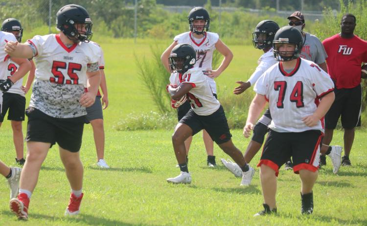 Fort White running back Tavion Taylor carries the ball up the field during Tuesday’s practice. (JORDAN KROEGER/Lake City Reporter)