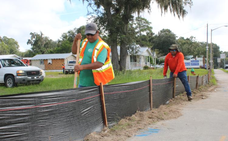Construction workers erect erosion control black fencing around the Circle K store site at the intersection of U.S. Highway 90 and Baya Drive Wednesday morning. The store is expected to be completed within 22 weeks. (TONY BRITT/Lake City Reporter)