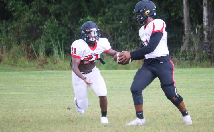 Fort White quarterback Tyler Jefferson hands the ball off to running back Tavion Taylor during Wednesday’s practice. The Indians open the season tonight at Santa Fe. (JORDAN KROEGER/Lake City Reporter)