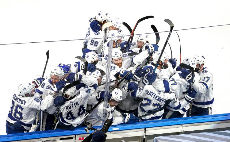 The Tampa Bay Lightning's Kevin Shattenkirk (22) is mobbed by his teammates after scoring the game-winning goal during the first overtime period for a 5-4 victory against the Dallas Stars in Game 4 of the Stanley Cup Finals on Friday, at Rogers Place in Edmonton, Canada. The Lightning lead the series, 3-1. (BRUCE BENNETT/Getty Images/TNS)