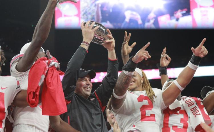 Ohio State coach Ryan Day holds up the trophy after their 34-21 come from behind win over Wisconsin at the Big Ten Championship Game at Lucas Oil Field on Dec. 7 2019, in Indianapolis. (DAVID PETKIEWICZ/cleveland.com/TNS)