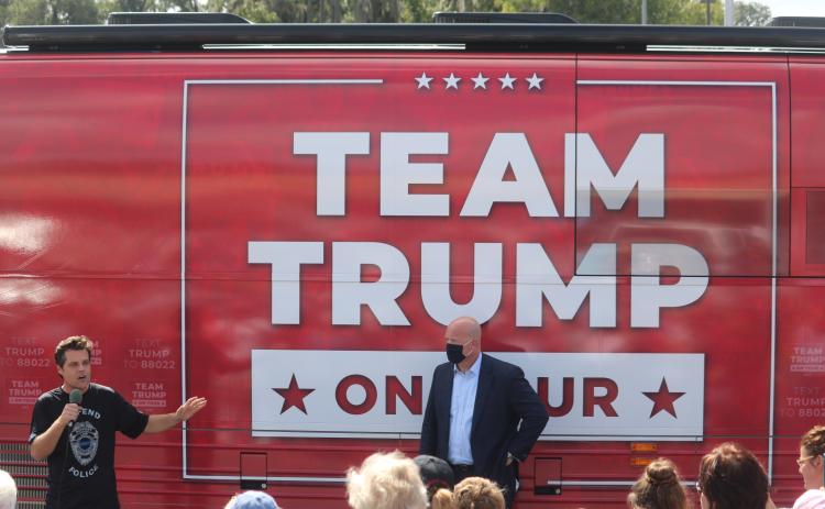 Matt Gaetz, a congressman from Florida’s First District in the panhandle, speaks during Monday’s rally in front of the Trump campaign bus while former acting U.S. Attorney General Matthew Whitaker looks on. More than 150 people attended the campaign stop at the Lake City Plaza. (TONY BRITT/Lake City Reporter)