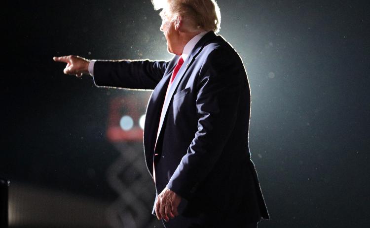 President Donald Trump waves goodbye to cheering supporters as he departs his campaign rally at Orlando Sanford International Airport in Sanford, Fla., on Monday. (JOE BURBANK/Orlando Sentinel/TNS)