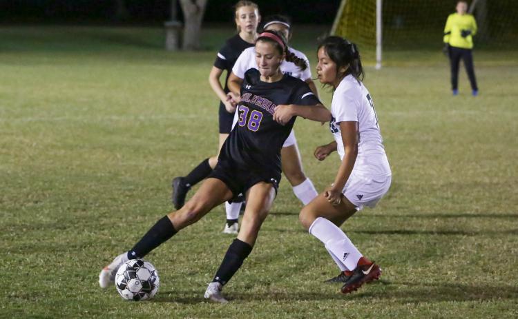 Columbia’s Skyler Ziegaus corrals possession from Suwannee’s Daisy De La Cruz on Thursday night. (BRENT KUYKENDALL/Lake City Reporter)