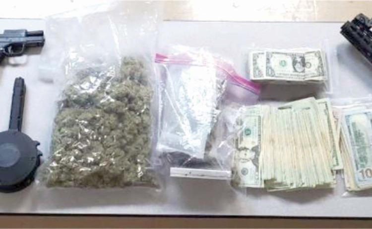 Four firearms, $10,000 in cash and 1.5 pounds of marijuana were found during a drug bust Thursday night sparked by a single-vehicle wreck. (COURTESY)