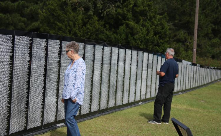 Nancy Chauncey and her husband Stanley Chauncey, of Lake City, look at names on the Vietnam Traveling Memorial Wall Thursday afternoon. The wall will be on display next door to the Honda of Lake City through Tuesday. (TONY BRITT/Lake City Reporter)