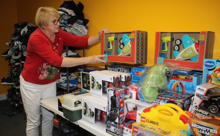 Meally Jenkins, Christmas Dream Machine founder and director, arranges toys in the agency’s office Friday afternoon. The Christmas Dream Machine opened Sunday and has already compiled a list of 100 children to serve this holiday season. (TONY BRITT/Lake City Reporter)