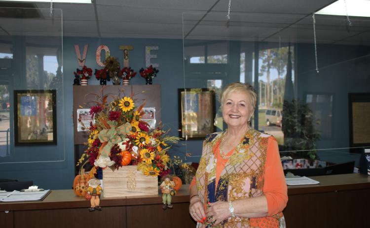 Liz P. Horne, the Columbia County supervisor of elections, stands at the elections office desk. Horne, who has worked at the office for more than 20 years, will retire on Dec. 31. (TONY BRITT/Lake City Reporter)