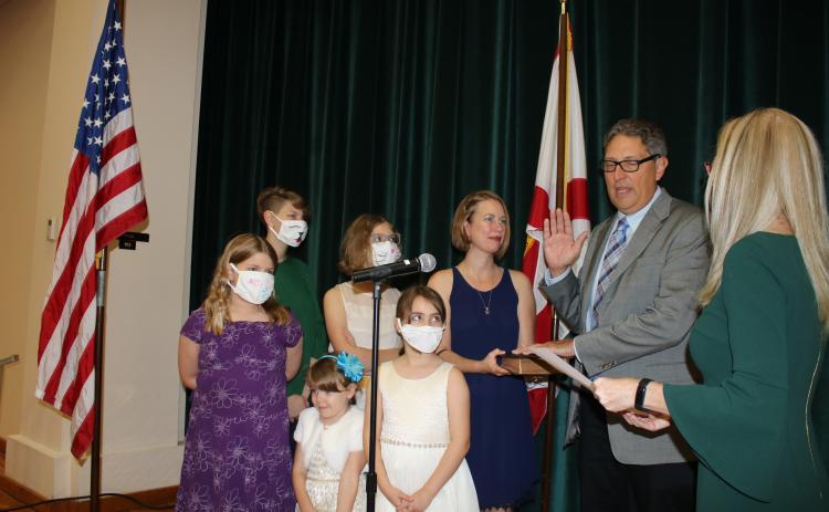 Lineah Sampson and Matilda Sampson (from row from left) stand with Lola Sampson (back row from left) Hannah Sampson, Aubree Sampson and Laura Sampson as Todd Sampson recites his oath of office Monday night. (TONY BRITT/Lake City Reporter)