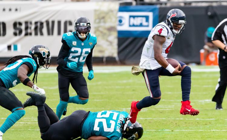 Houston Texans quarterback Deshaun Watson (4) leaps over Jacksonville Jaguars defensive tackle DaVon Hamilton (52) in the fourth quarter of Sunday's game in Jacksonville. (TRIBUNE NEWS SERVICE)