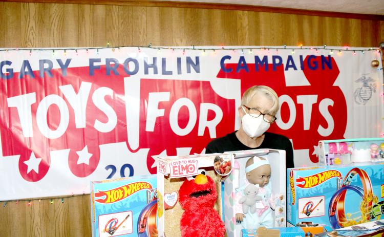 Inga Dwyer, Toys for Tots coordinator for Columbia and Suwannee counties, stands behind a row of toys in her office on Wednesday. (TONY BRITT/Lake City Reporter)