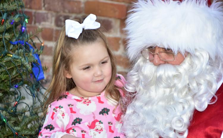 Santa Claus listens to a girl’s wish list Saturday at the 36th annual Christmas on the Square in Live Oak. (ROB WOLFE/Special to the Reporter)
