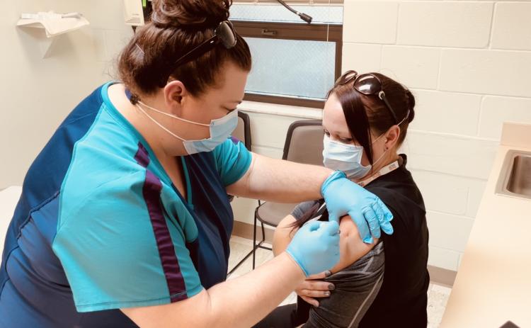 Front line staff member Sara Driggers (left) administers the first Moderna covid-19 vaccine allocated to the Columbia County Health Department to Sarah White. The health department will begin administering vaccinations to residents, 65 and older, on Monday. (COURTESY)