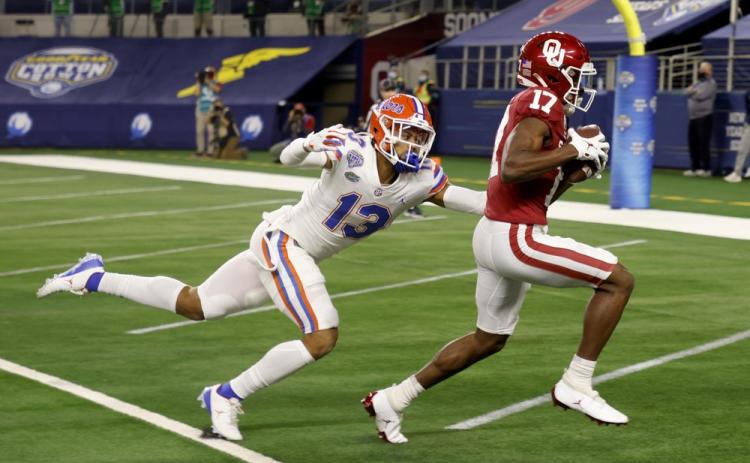 Florida defensive back Donovan Stiner (13) is unable to stop Oklahoma wide receiver Marvin Mims (17) from reaching the end zone on a touchdown reception during the first half of the Cotton Bowl on Wednesday in Arlington, Texas. (MICHAEL AINSWORTH/Associated Press)