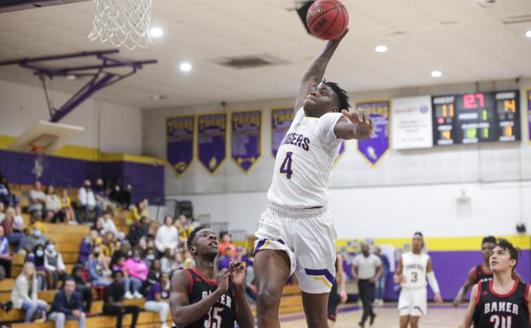 Columbia forward Marcus Peterson flies toward the basket for a slam dunk against Baker County on Friday night. Peterson finished with a game-high 16 points for the Tigers. (BRENT KUYKENDALL/Lake City Reporter)