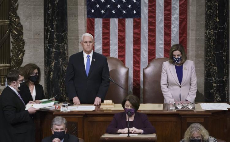 Vice President Mike Pence and Speaker of the House Nancy Pelosi, D-Calif., read the final certification of Electoral College votes cast in November's presidential election during a joint session of Congress after working through the night and into Thursday at the Capitol in Washington. Violent protesters loyal to President Donald Trump stormed the Capitol Wednesday, disrupting the process. (J. SCOTT APPLEWHITE/AP Pool Photo)