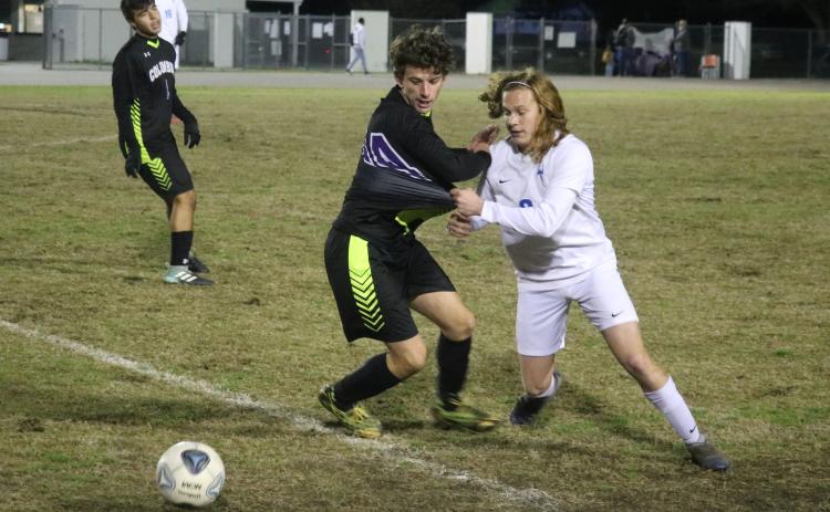 Columbia’s Trey Hingson chases after possession of the ball with Clay’s Ryan Borsheim on Thursday. (JORDAN KROEGER/Lake City Reporter)