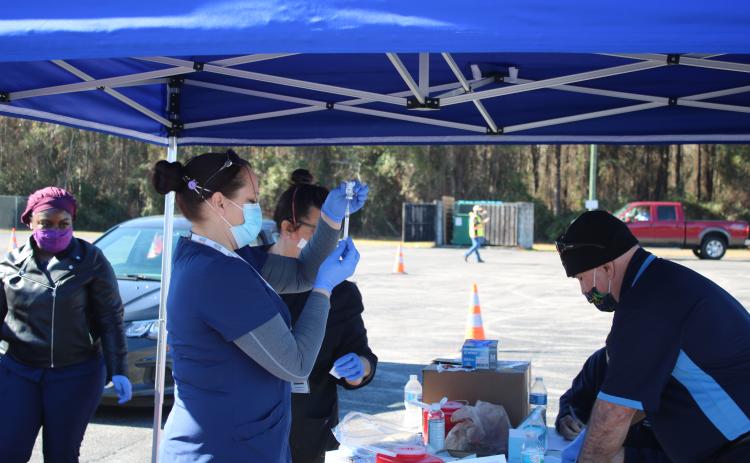 Sara Driggers fills a syringe with the Moderna covid-19 vaccination Monday morning as local residents 65 and older get inoculated. The Columbia County Health Department vaccinated 530 people on Monday. Roughly 3,200 people have registered for the vaccination already. (TONY BRITT/Lake City Reporter)