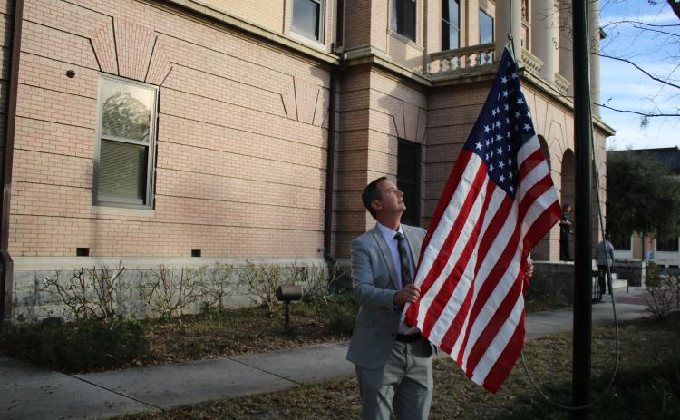Jay Swisher, Columbia County Clerk of Court, hoists a flag over the Columbia County Courthouse Wednesday that was flown over the U.S. Capitol. (TONY BRITT/Lake City Reporter)