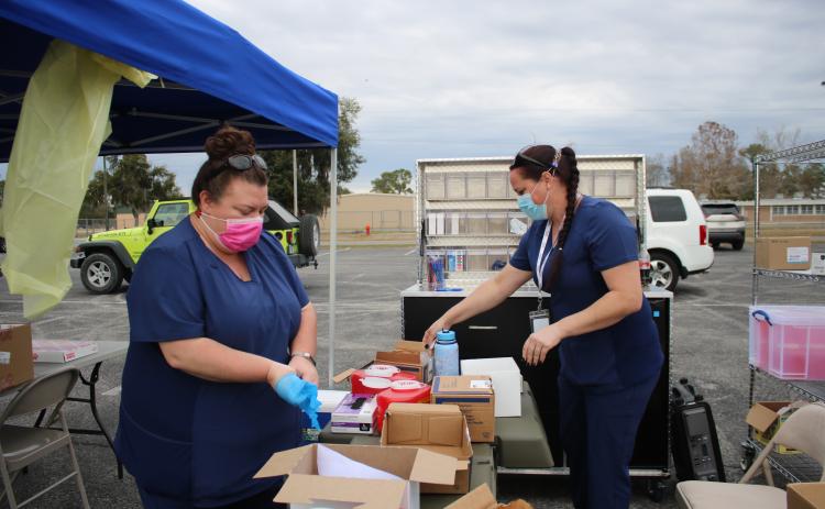Sarah White (left) and Sara Driggers, Columbia County Health Department nurses, pack up vaccination supplies after helping to vaccinate 630 residents with the covid-19 vaccine on Thursday. The workers vaccinated 630 people in six hours. (TONY BRITT/Lake City Reporter)