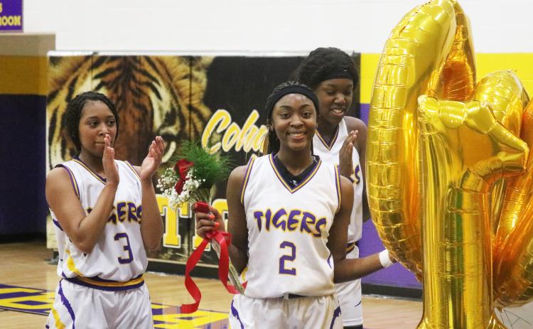 Columbia point guard Na’Haviya Paxton is congratulated by teammates after scoring the 1,000th point of her career during the second quarter of Thursday’s game against Countryside Christian. Paxton was presented with a bronze basketball trophy, balloons, flowers and a poster signed by all of her teammates that read, ‘Na’Haviya gets 1,000 buckets.’ (JORDAN KROEGER/Lake City Reporter)
